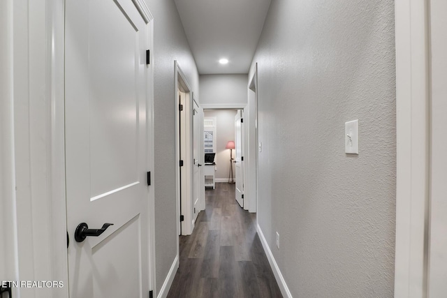 corridor with dark hardwood / wood-style flooring