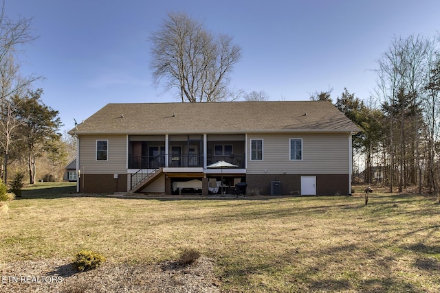 back of property with a sunroom, central AC unit, and a lawn