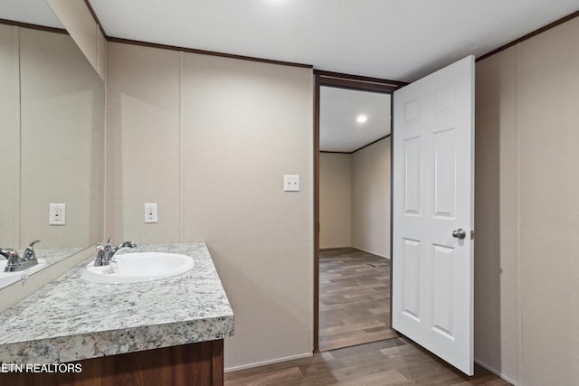 bathroom featuring crown molding, vanity, and hardwood / wood-style floors