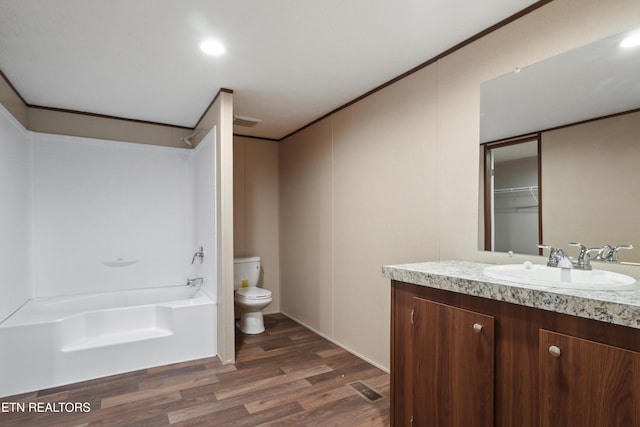 full bathroom featuring hardwood / wood-style flooring, vanity, toilet, and bathtub / shower combination