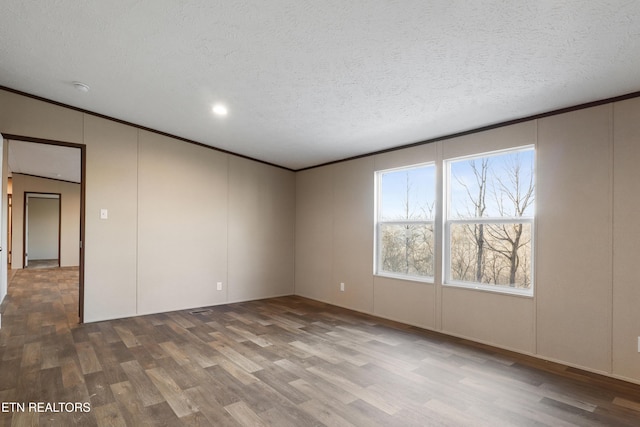 empty room with wood-type flooring and a textured ceiling