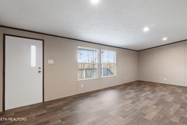 foyer entrance with dark hardwood / wood-style floors and a textured ceiling