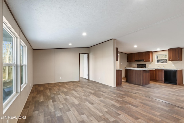 kitchen featuring a textured ceiling, ornamental molding, a kitchen island, hardwood / wood-style flooring, and black appliances