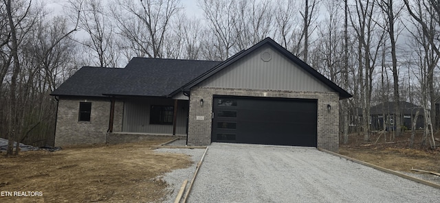 view of front of home with brick siding, driveway, and a garage