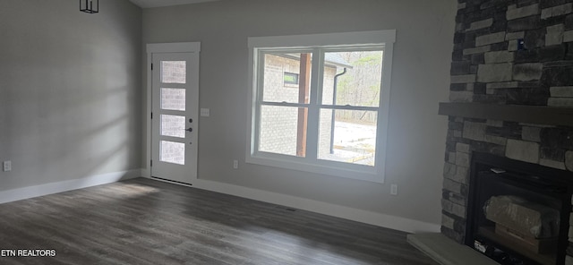 living area featuring dark wood-style floors, a fireplace, and baseboards