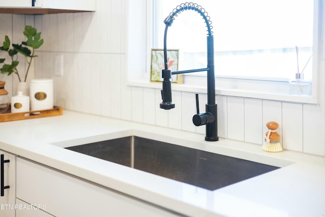 interior details featuring sink and white cabinets