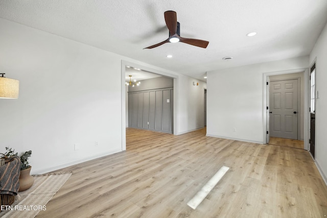 unfurnished living room with ceiling fan, light hardwood / wood-style flooring, and a textured ceiling