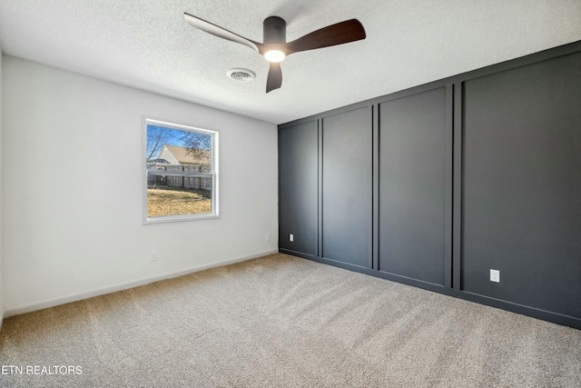 unfurnished bedroom featuring ceiling fan, carpet floors, a closet, and a textured ceiling