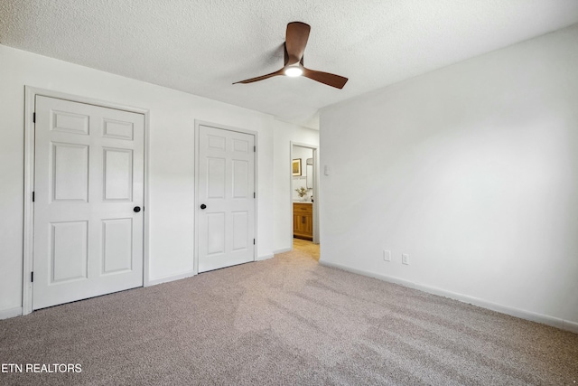 unfurnished bedroom featuring ceiling fan, light colored carpet, and a textured ceiling