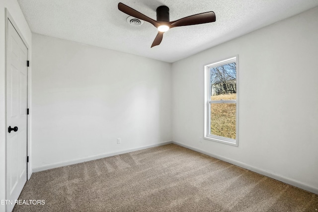 spare room featuring ceiling fan, carpet, and a textured ceiling