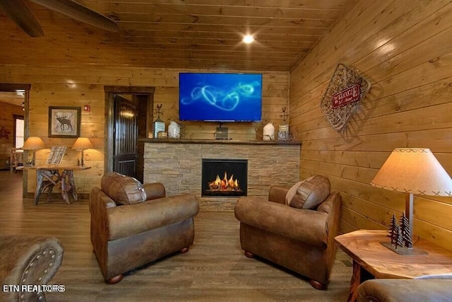 living room with wood ceiling, a stone fireplace, and hardwood / wood-style flooring