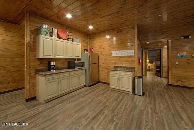 kitchen with wood ceiling, stainless steel appliances, and wood walls