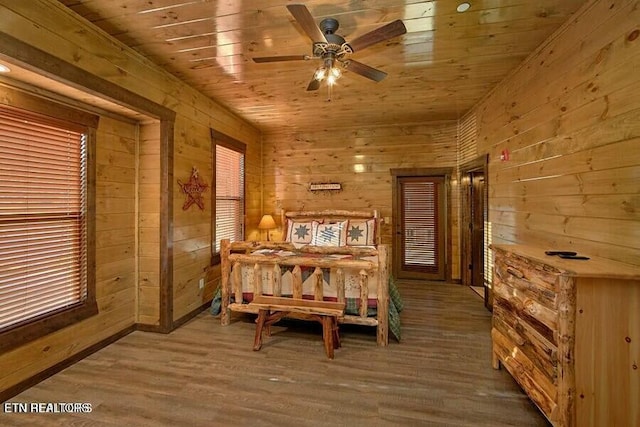 dining space featuring hardwood / wood-style floors, wooden ceiling, ceiling fan, and wood walls