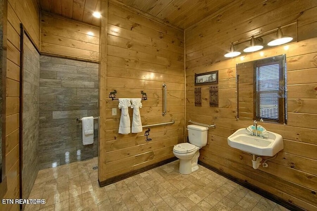 bathroom featuring toilet, wooden walls, sink, and wooden ceiling