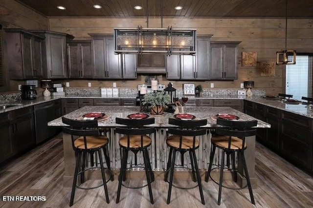 kitchen featuring wooden walls, light stone countertops, and a center island