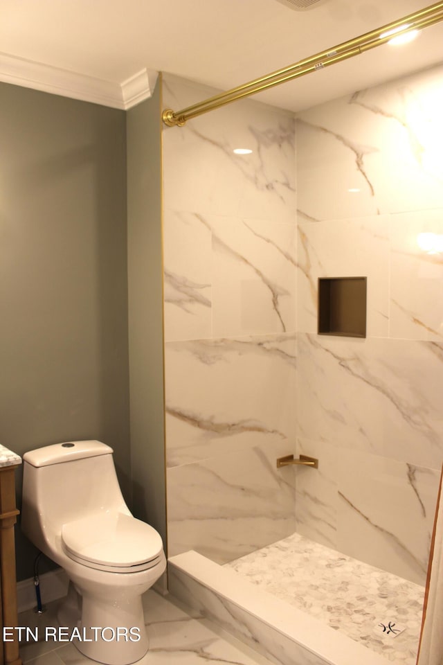 bathroom featuring vanity, tiled shower, ornamental molding, and toilet