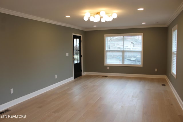 spare room featuring ornamental molding, a chandelier, and light hardwood / wood-style floors