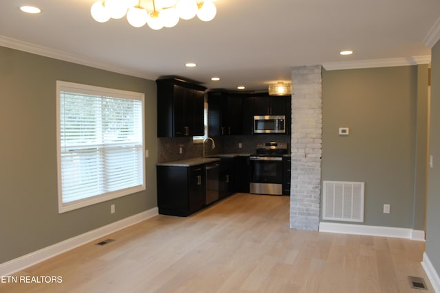 kitchen featuring stainless steel appliances, ornamental molding, backsplash, and light hardwood / wood-style flooring