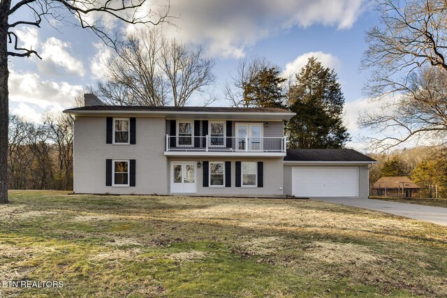 view of front of property featuring a garage, a front lawn, and a balcony