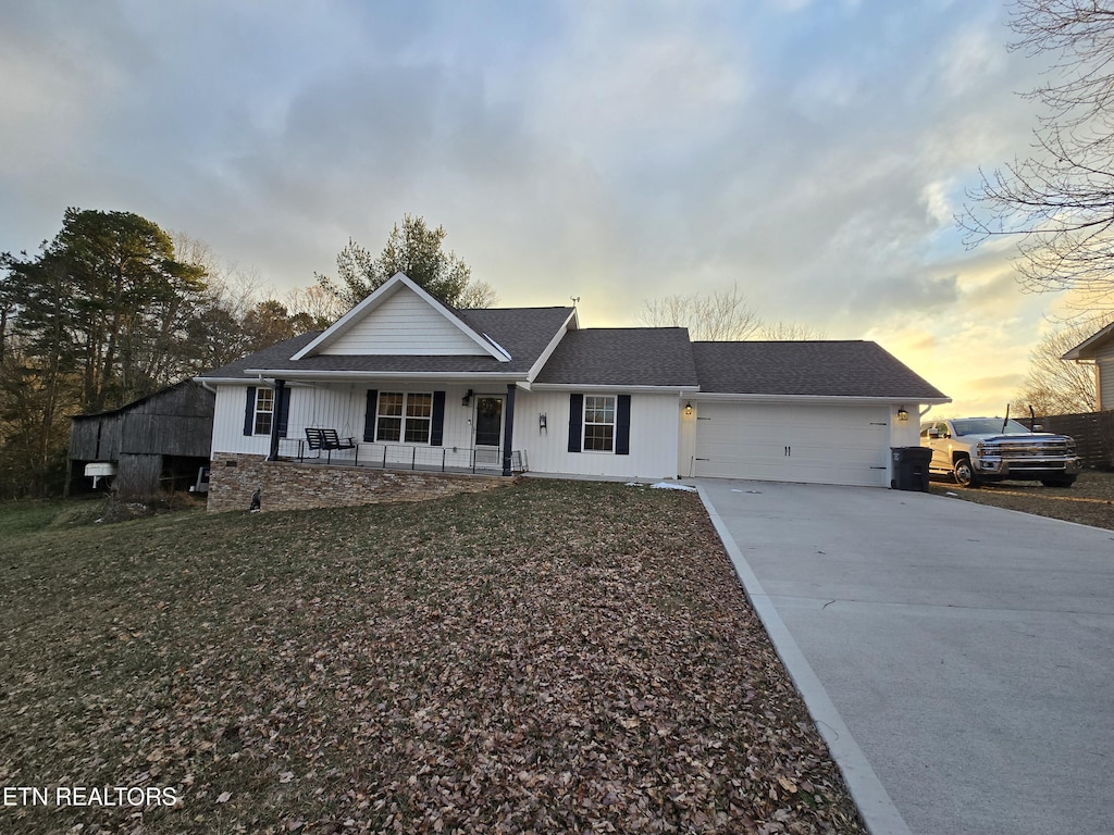 ranch-style house with a garage and covered porch