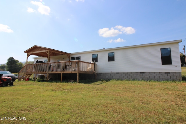 back of house with a wooden deck and a yard