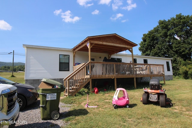 back of house with a wooden deck and a yard