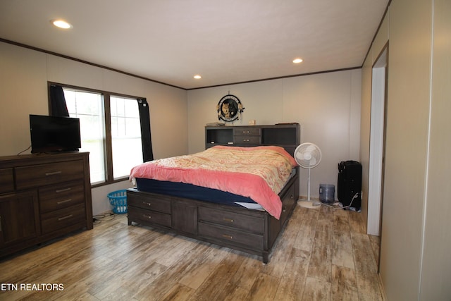 bedroom with ornamental molding and light wood-type flooring