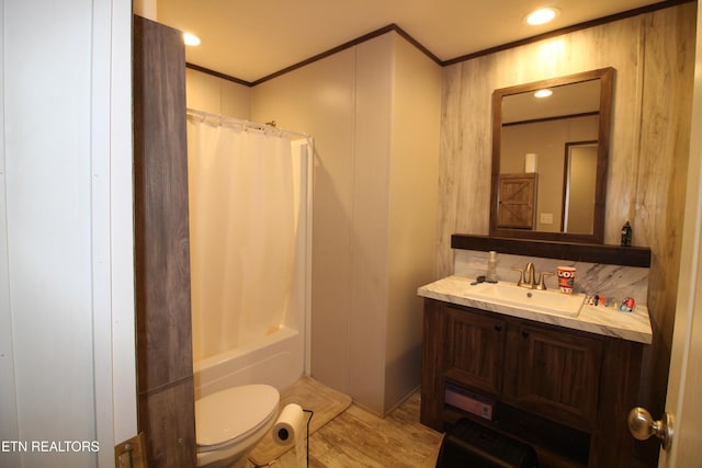 full bathroom featuring hardwood / wood-style flooring, ornamental molding, vanity, shower / tub combo, and toilet