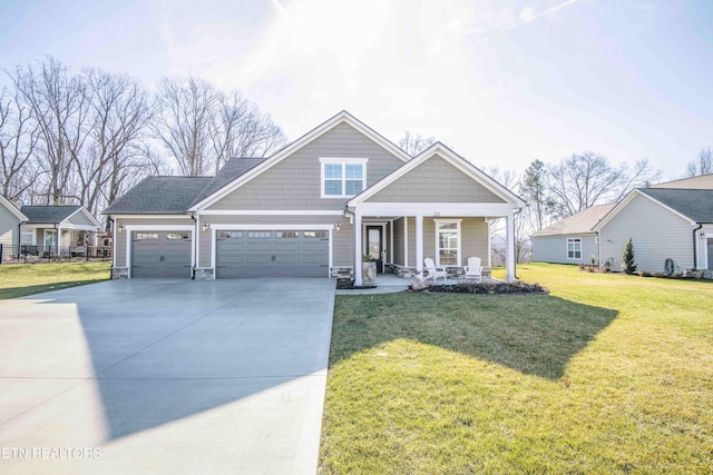 craftsman house featuring a garage, a front yard, and covered porch