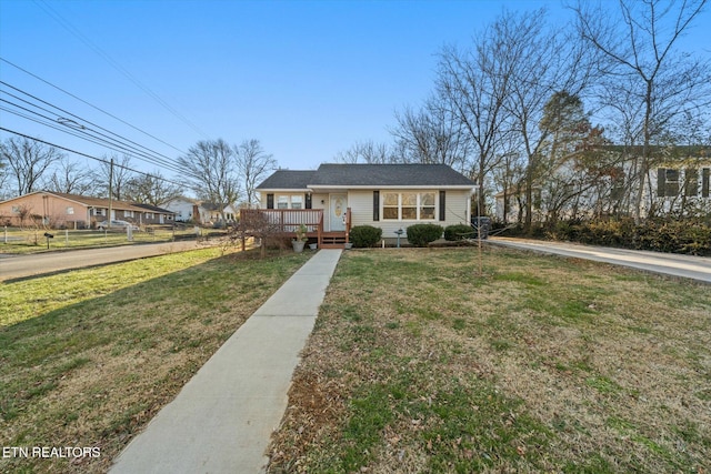 view of front of property with a deck and a front lawn