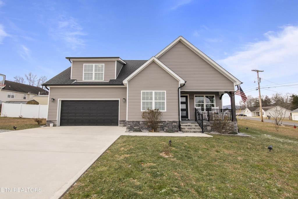 view of front facade with a garage, a front lawn, and covered porch