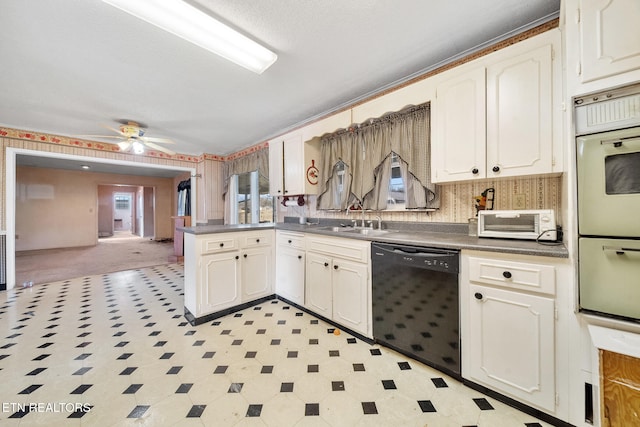 kitchen featuring black dishwasher, a toaster, light floors, white cabinets, and a sink