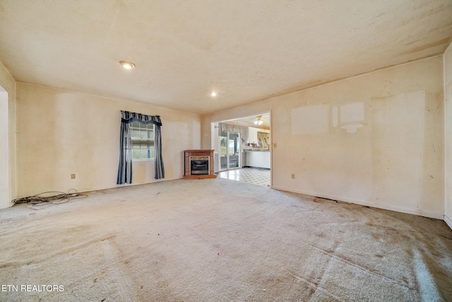 unfurnished living room with carpet and a glass covered fireplace