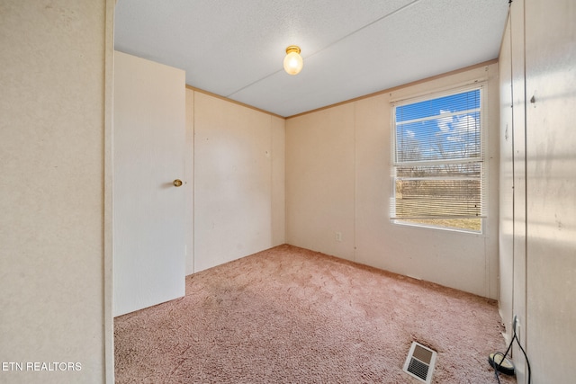 carpeted empty room featuring visible vents