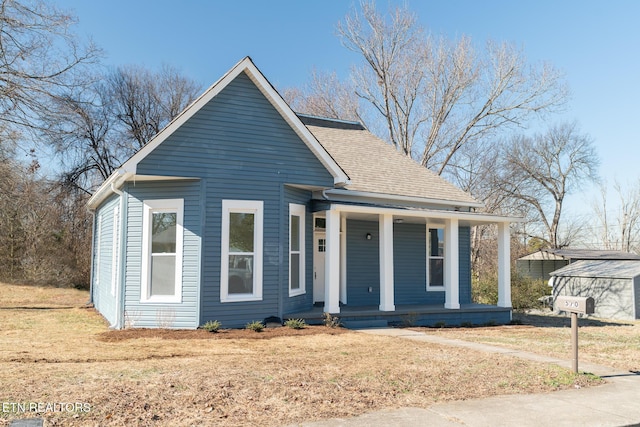 bungalow-style house featuring covered porch and a front yard