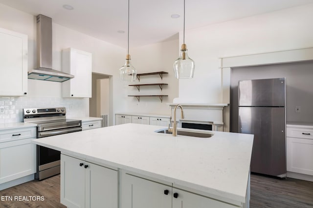 kitchen with appliances with stainless steel finishes, sink, white cabinets, and wall chimney exhaust hood