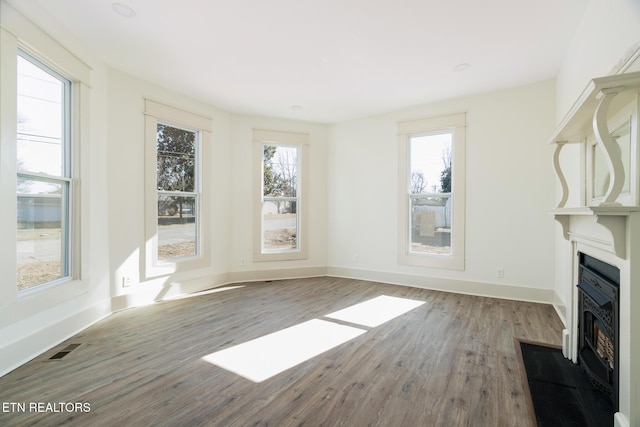 unfurnished living room with hardwood / wood-style flooring and a wealth of natural light