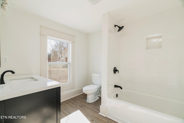 full bathroom featuring hardwood / wood-style flooring, tiled shower / bath, vanity, and toilet