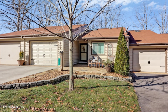 ranch-style home featuring a garage and a front lawn