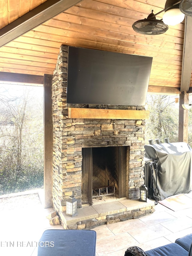 details featuring a stone fireplace and ceiling fan