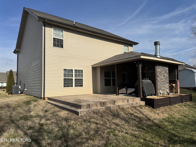 rear view of house with central air condition unit, a patio area, and a lawn