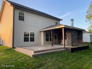 back of house featuring a lawn