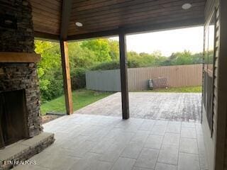 view of patio with fence and an outdoor fireplace