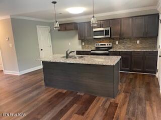 kitchen featuring crown molding, a sink, stainless steel appliances, and decorative backsplash