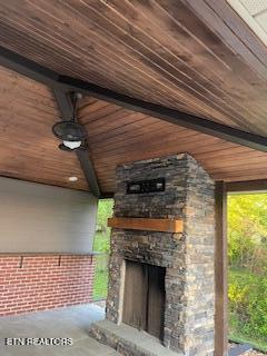 view of patio featuring an outdoor stone fireplace