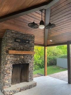 view of patio featuring ceiling fan and exterior fireplace