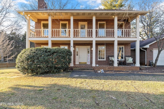 view of front of house featuring a balcony and a front yard