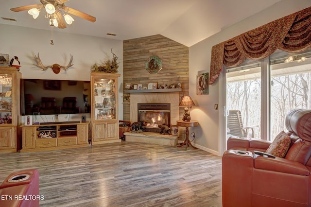 living room featuring lofted ceiling, hardwood / wood-style floors, a fireplace, and ceiling fan