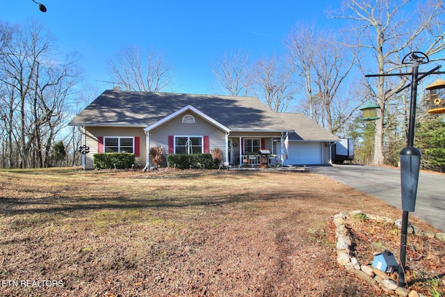 view of front of property featuring a porch, a garage, and a front yard