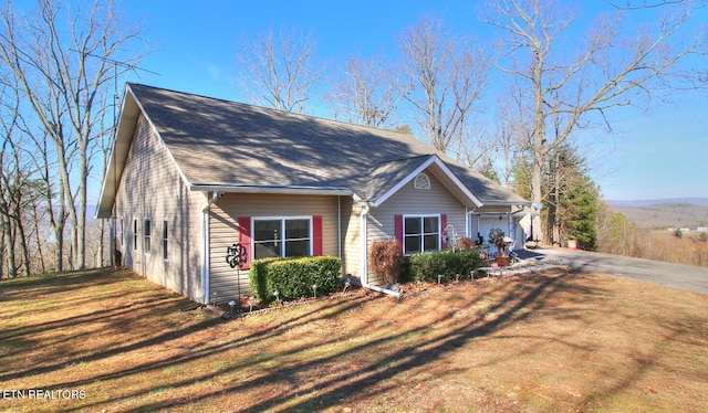 view of side of home with a garage and a lawn